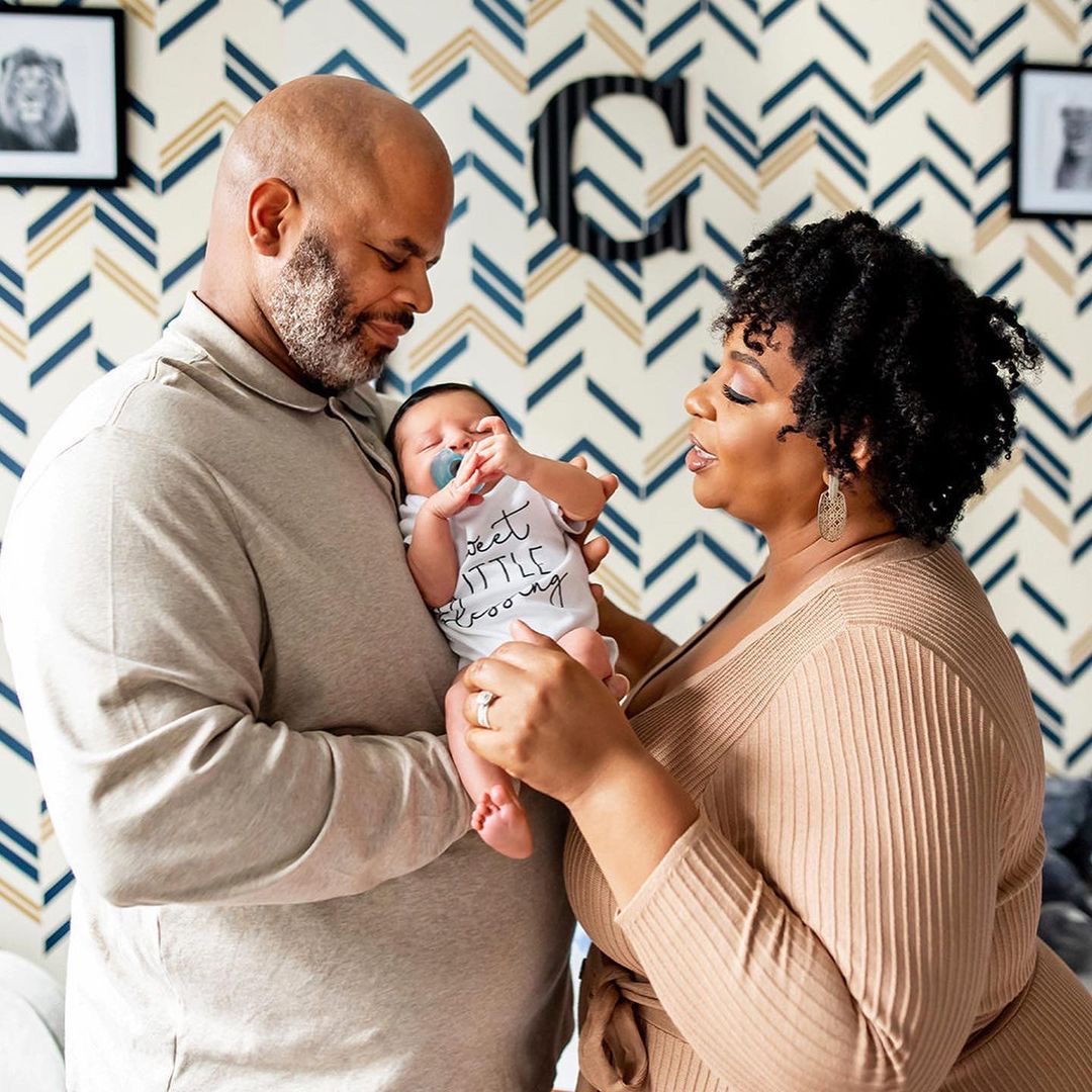 Tamika Felder touches her newborn son Chayton's foot while looking at him lovingly. Her husband Juan "Rocky" Campbell holds Chayton, who has a pacifier in his mouth.