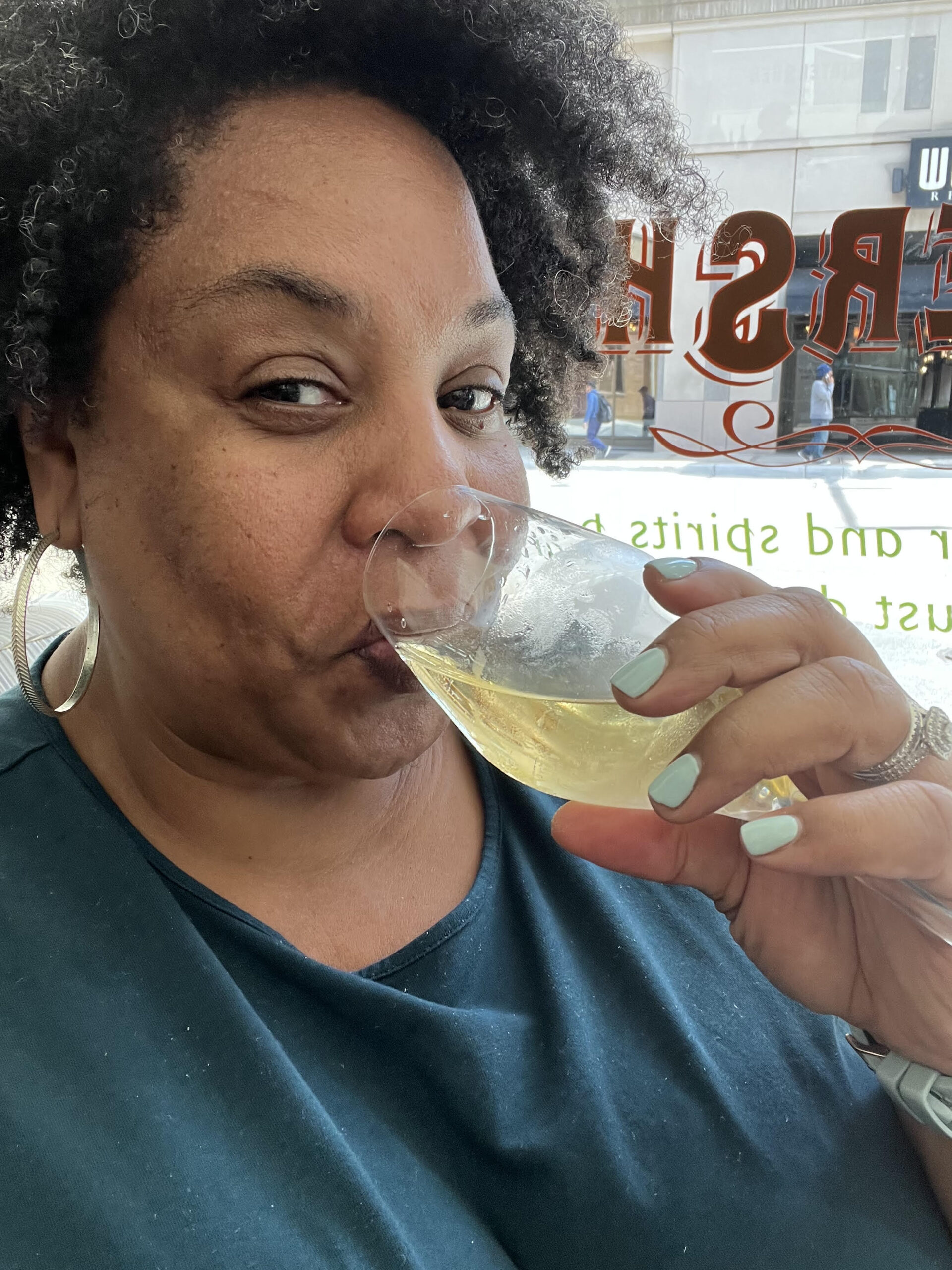 Tamika Felder, a global cancer advocate and cervical cancer survivor, wearing a teal shirt, toasting with champagne for her cancer-versary on National Cancer Survivors Day, June 3, 2024.