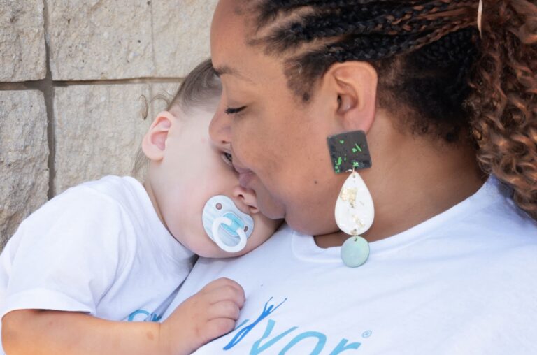 Tamika Felder, a cancer survivor and global advocate for fertility rights, tenderly looks at her young son, born through embryo donation and gestational surrogacy. This moment captures their special bond and reflects her unique fertility journey.